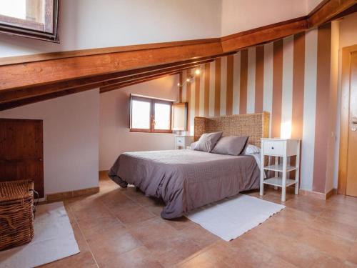 una camera con un letto in una stanza con pareti a strisce di Apartamento Rural en Terminon a Terminón