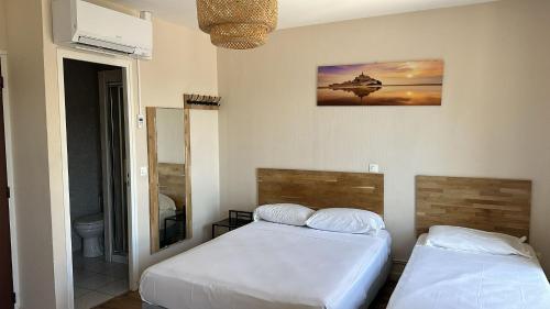 a bedroom with two beds and a mirror at HOTEL IN PARIS in Aubervilliers