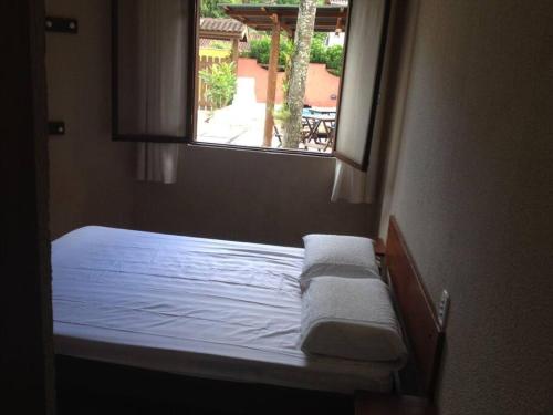 un letto in una stanza con una finestra di Linda Casa em Boiçucanga - São Sebastião, 4 suítes a São Sebastião
