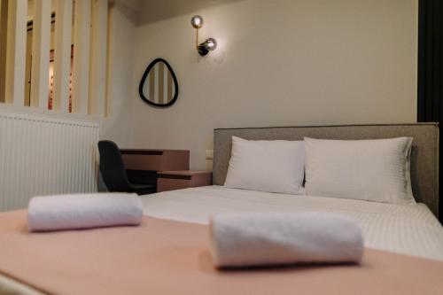 a bedroom with a bed with white sheets and a chair at Anassa House in Alexandroupoli