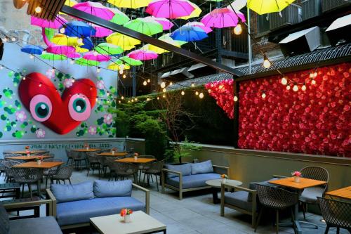 a restaurant with tables and umbrellas hanging from the ceiling at INNSiDE by Meliá New York Nomad in New York