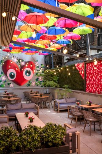 a restaurant with tables and umbrellas hanging from the ceiling at INNSiDE by Meliá New York Nomad in New York