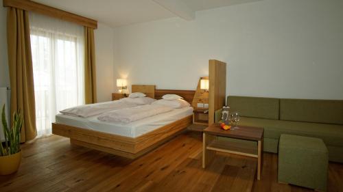 a bedroom with a large bed and a table at Hotel Sterzinger Moos in Vipiteno