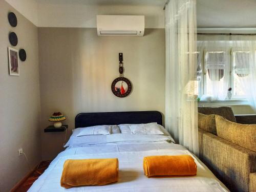 a bedroom with a bed with orange pillows on it at Belvárosi Studio Apartman in Győr