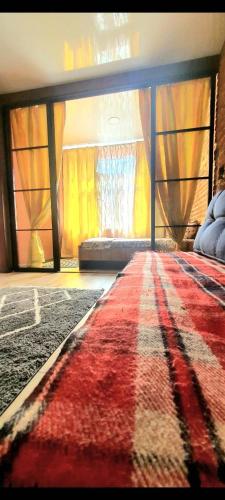 a bedroom with a rug and a bed with a window at LOFT in Down Town in Dnipro