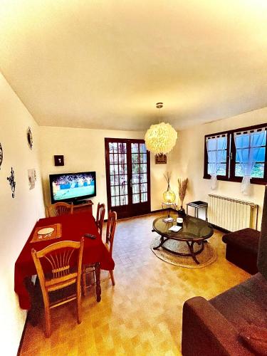 a living room with a table and a couch at Au pays d'Hector Berlioz in La Côte-Saint-André