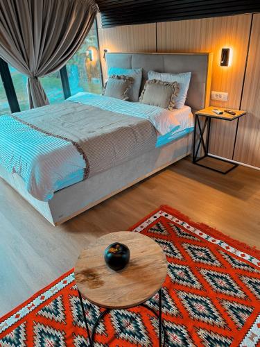 a bedroom with a large bed and a table at Guesthouse Prrockaj Theth in Theth