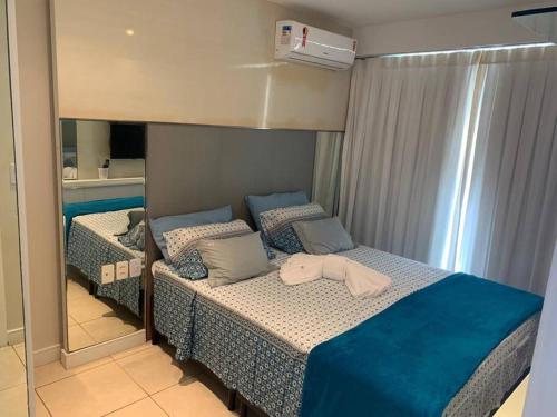 a bedroom with a bed with a mirror on it at Beach Village - Praia do Futuro II in Fortaleza