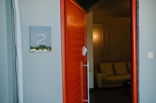 an orange door leading to a room with a couch at Anassa House in Alexandroupoli
