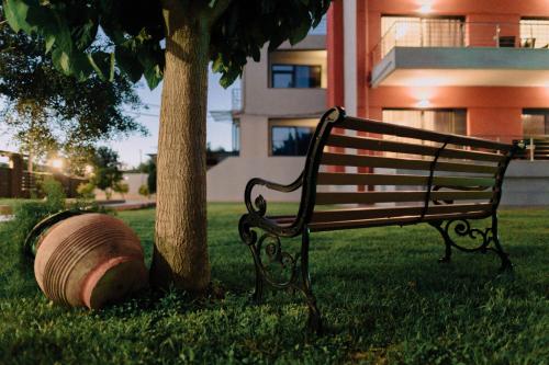 a park bench next to a tree and a barrel at Anassa House in Alexandroupoli