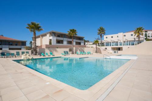 a swimming pool at a resort with palm trees at Location d’un Superbe appartement avec piscine in Roquebrune-sur-Argens
