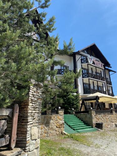 a large building with green steps in front of it at Shulc in Bukovel