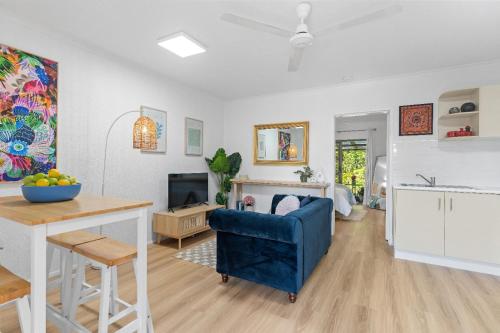 a living room with a blue chair and a table at Botanical Bliss in Edge Hill