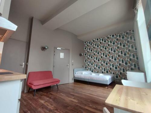 un salon avec une chaise rouge et un canapé dans l'établissement Appartement 1er étage sur cour aux Chartrons, à Bordeaux