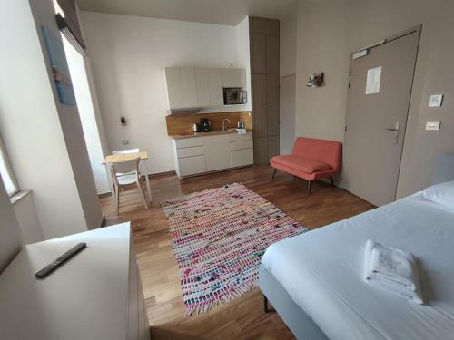 - un salon avec un lit et une chaise rouge dans l'établissement Appartement 1er étage sur cour aux Chartrons, à Bordeaux