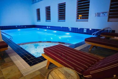 a large swimming pool with a bench and a bench at Grand Villaggio Hotel Abu Dhabi in Abu Dhabi