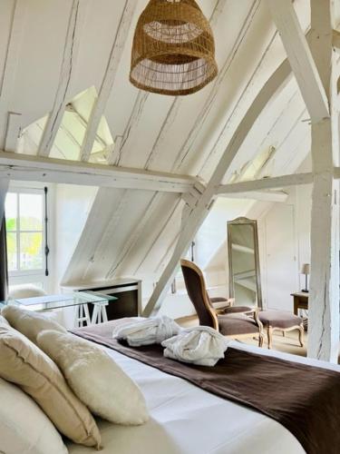 une chambre avec un lit et une chaise dans une pièce dans l'établissement Hôtel Saint-Laurent, The Originals Relais, à Montfort-lʼAmaury