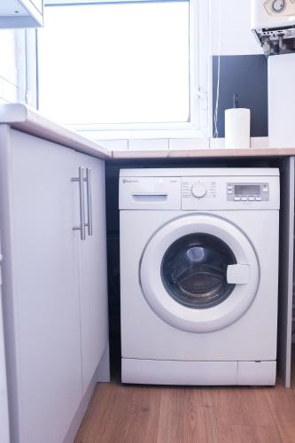 a white washer and dryer in a laundry room at Portsmouth Apartment *Newly refurbished *Central in Portsmouth