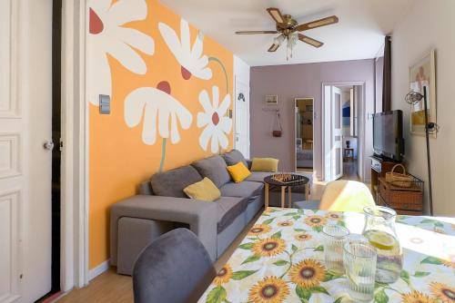 un salon avec un canapé et une table dans l'établissement T3 clim, TV, ART, familial, 50m du port, cuisine équipée et jeux de société, à Port-Vendres