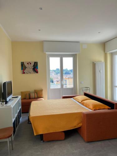 a bedroom with a large bed and a couch at Testa tra le Nuvole in Novi Ligure