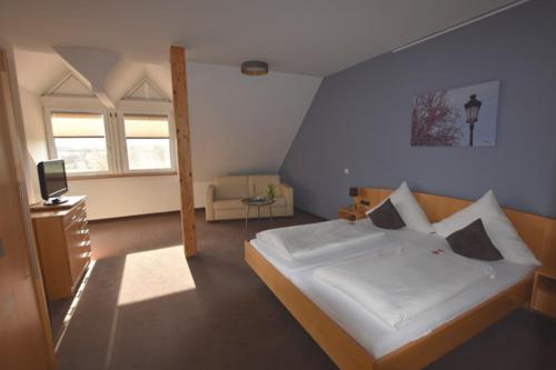 a bedroom with a large white bed and a window at Landhotel Hauer in Pleisweiler-Oberhofen