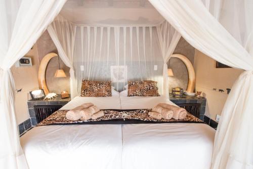 a bedroom with a bed with two pillows at African Rock Lodge in Hoedspruit