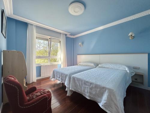 Un dormitorio azul con una cama y una silla. en El Rancho - 13801, en Güemes