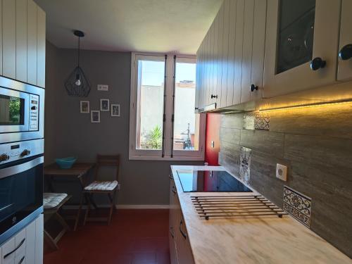 a kitchen with a counter top and a window at Casa na praia - com piscina in Esmoriz