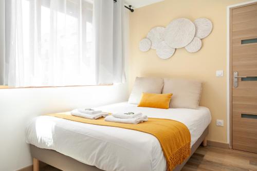 une chambre avec un lit avec deux serviettes dessus dans l'établissement Hoche Apartment - PSG, à Le Pré-Saint-Gervais