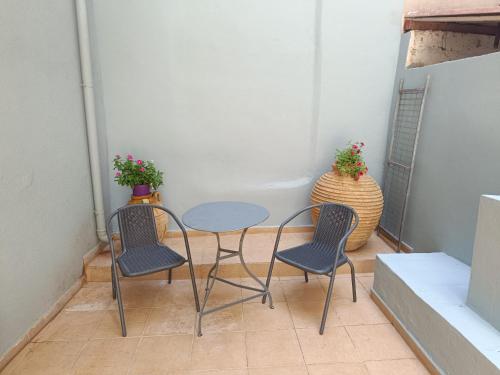 a small table and two chairs and a table with two plants at Διατίθεται Γκαρσονιέρα in Kalamata