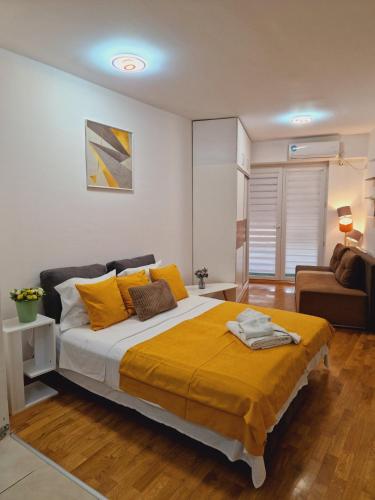 ein Schlafzimmer mit einem großen Bett und gelben Kissen in der Unterkunft Kamche apartment in Skopje