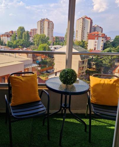 einen Tisch und Stühle auf einem Balkon mit Stadtblick in der Unterkunft Kamche apartment in Skopje