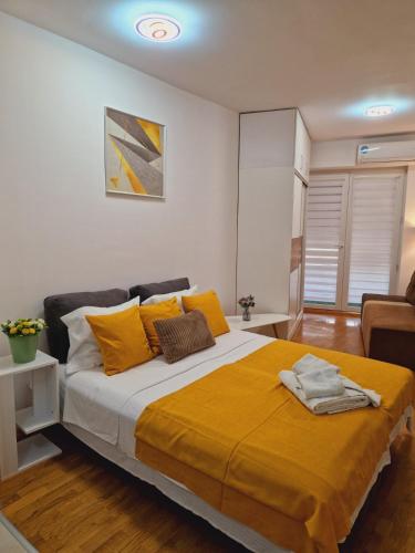 a bedroom with a large bed with yellow pillows at Kamche apartment in Skopje