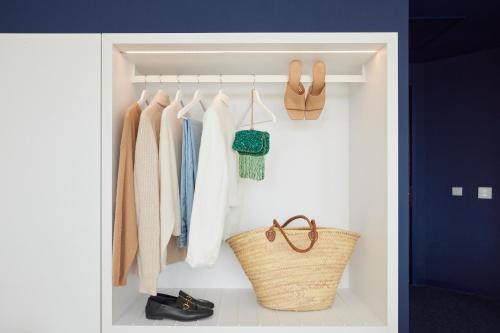 a walk in closet with shoes and a basket at C-Hotels Burlington in Ostend