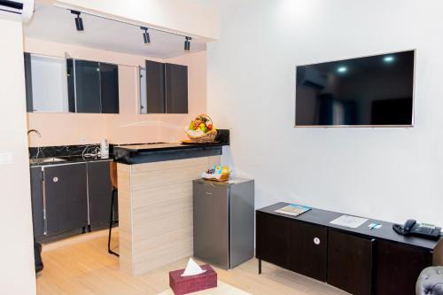 a kitchen with a counter and a tv on the wall at Bano Palace Hotel in Douala