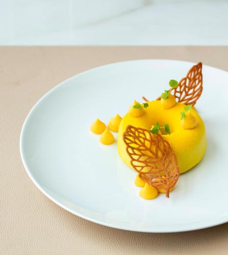 a yellow dessert with butterflies on a white plate at SCHLOSS Roxburghe, part of Destination by Hyatt in Kelso