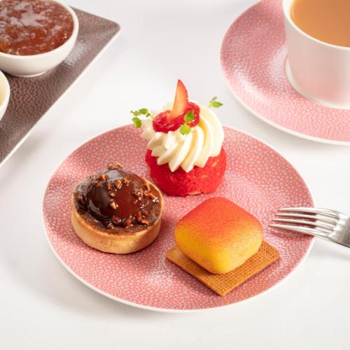 a pink plate with two pastries on a table at SCHLOSS Roxburghe, part of Destination by Hyatt in Kelso