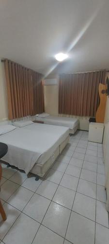 a room with two beds and a guitar in it at Hotel Praia 2000 in Fortaleza