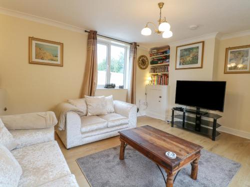 a living room with a couch and a tv at Tiffany's Cottage in Great Yarmouth