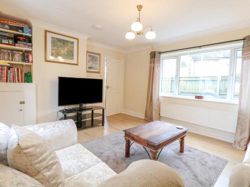 a living room with a couch and a tv at Tiffany's Cottage in Great Yarmouth