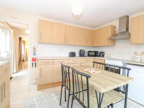 a kitchen with a wooden table and chairs at Tiffany's Cottage in Great Yarmouth