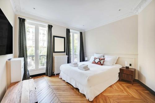 - une chambre blanche avec un grand lit et des fenêtres dans l'établissement Charming apt - 2BR-4P - Arc de Triomphe, à Paris