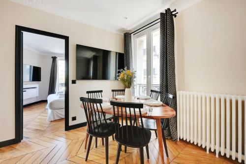 une salle à manger avec une table et quatre chaises dans l'établissement Charming apt - 2BR-4P - Arc de Triomphe, à Paris