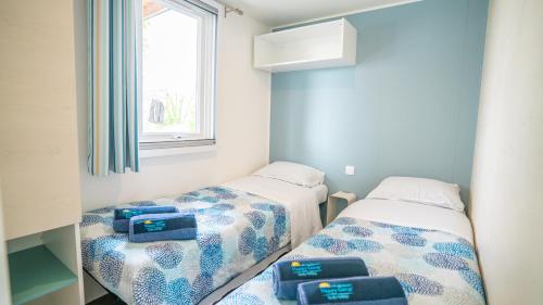 A bed or beds in a room at Happy Camp Mobile Homes in Camping Cisano San Vito