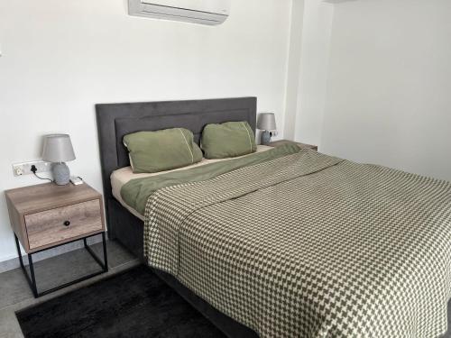 a bed with two green pillows and a night stand at Retreat B1-9 in Akanthou