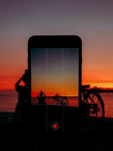 a person is looking at a picture of a sunset at Leaf Coco Bungalow in Gili Air