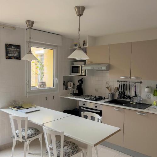 - une cuisine avec une table blanche et des chaises blanches dans l'établissement Cottage OMAHA - 3 personnes - Plages du débarquement, à Formigny