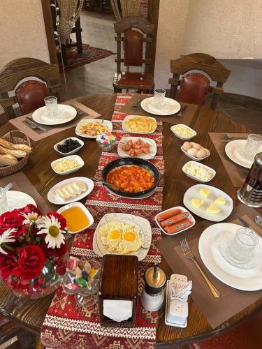 a wooden table with plates of food on it at Senger Qala in Qax