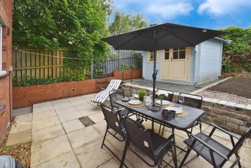 a table with an umbrella on a patio at Beautiful house in Clydebank in Glasgow