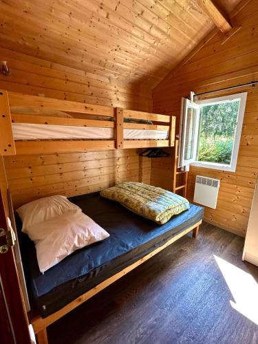 - une chambre avec des lits superposés dans une cabane en rondins dans l'établissement Camping Onlycamp L'Orée d'Alsace, à Wasselonne